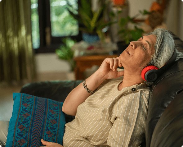Elderly woman relaxing with headphones, eyes closed, and peaceful expression.