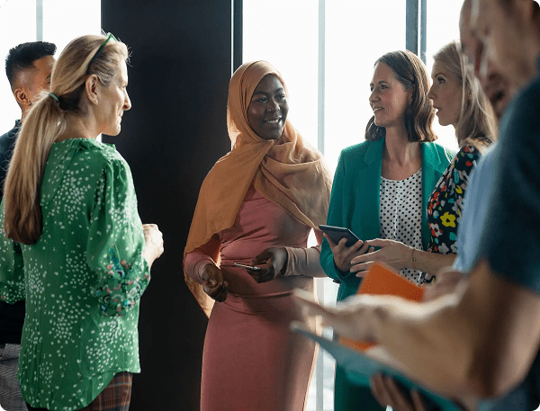 A diverse group of women engaged in a discussion in a bright room.