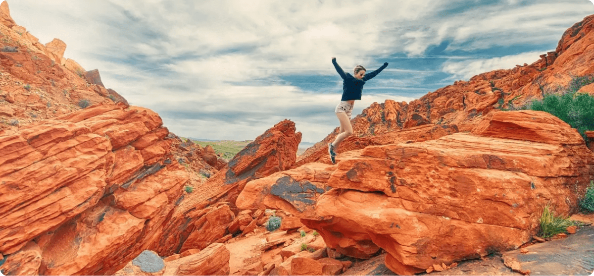 Excited jump amid red rock formations